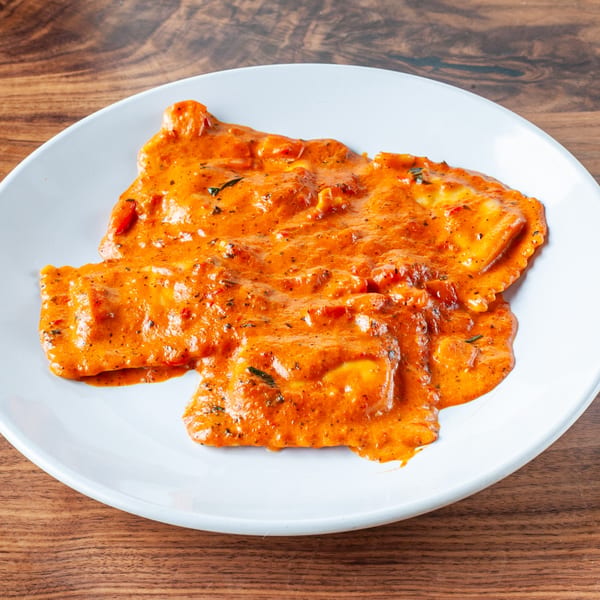 Verona Italian Cafe's ravioli pasta covered in a rich, creamy orange sauce on a white plate.
